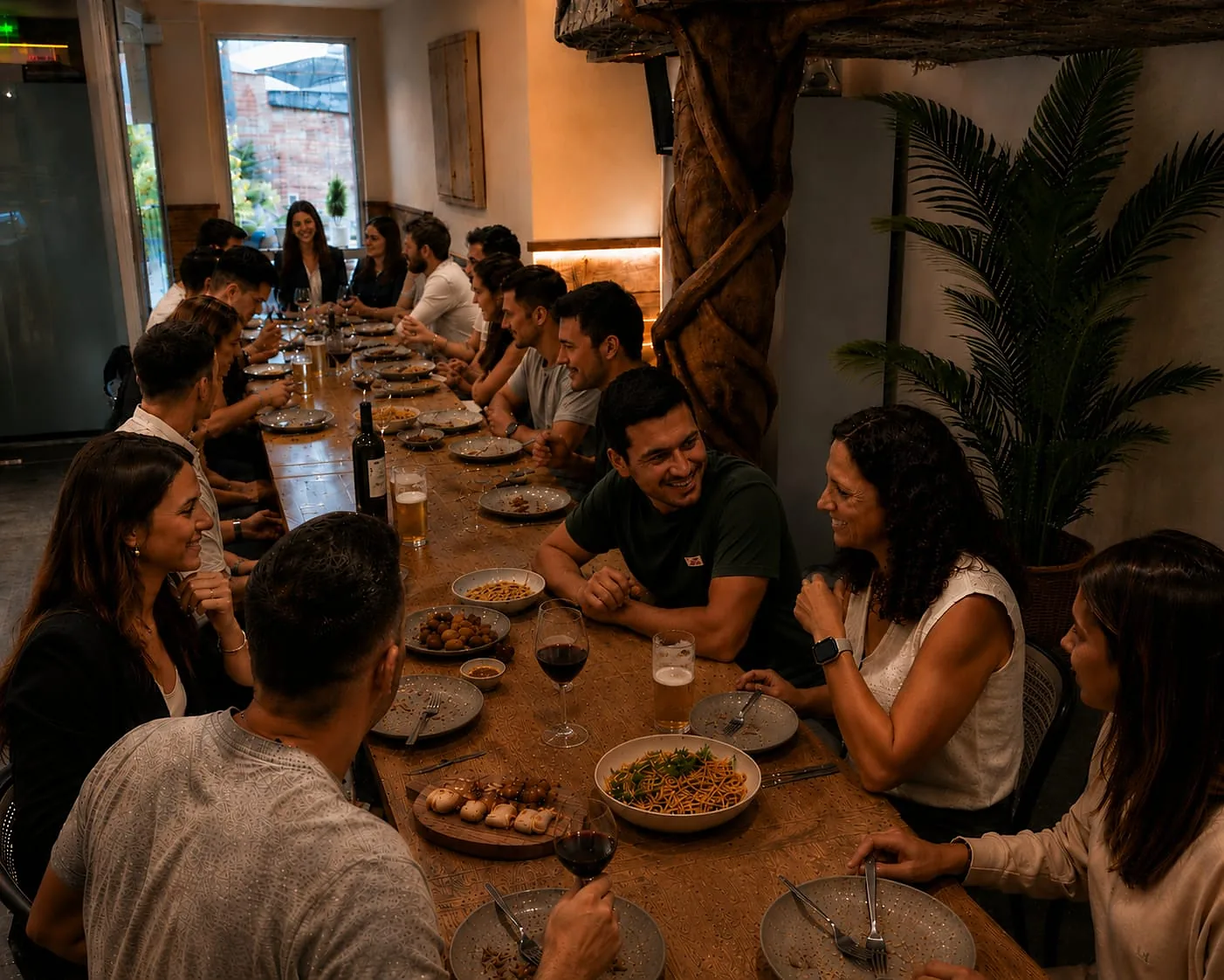 Mesa corrida con más de veinte comensales y la comida servida al centro en El Gato Volador